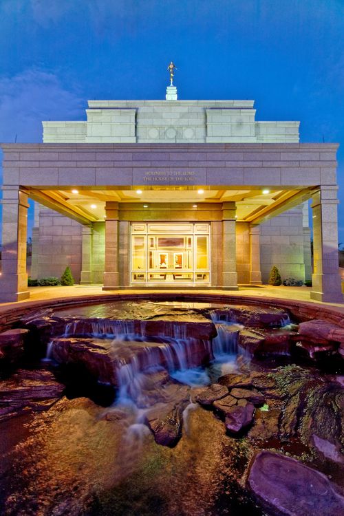 The entrance of the Snowflake Arizona Temple all lit up in the early evening, with the fountain in front.