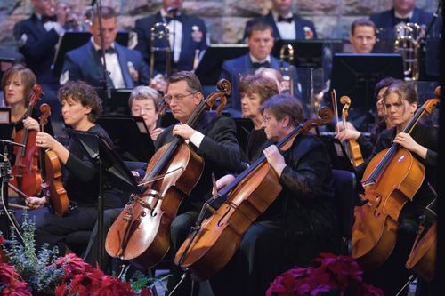 The orchestra playing in the Conference Center, with the women dressed in black and the men in white shirts and suits.
