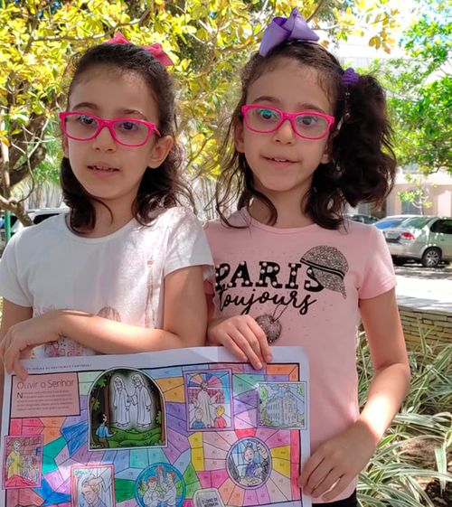 Picture of Suzana and Lucia Rohamis Tabosa wearing pinks glasses and holding a picture.