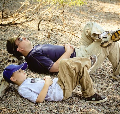 father and son taking nap outside