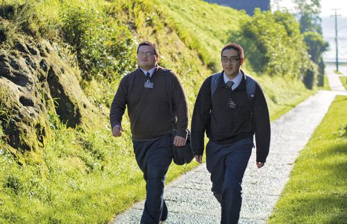 two male missionaries walking on path