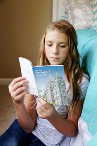 youth reading from the For the Strength of Youth pamphlet