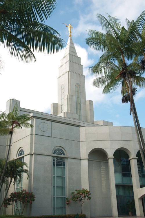 The spire of the Recife Brazil Temple, including a partial view of the entrance to the temple and the trees on the grounds around the temple.