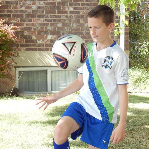 boy juggling soccer ball