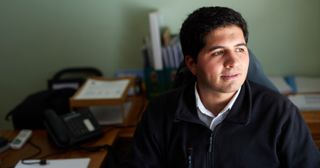 a young adult sits at a desk