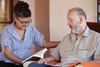 Woman reading a book to an older man