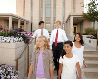 Young men and women walking away from the Oquirrh Mountain Utah Temple.