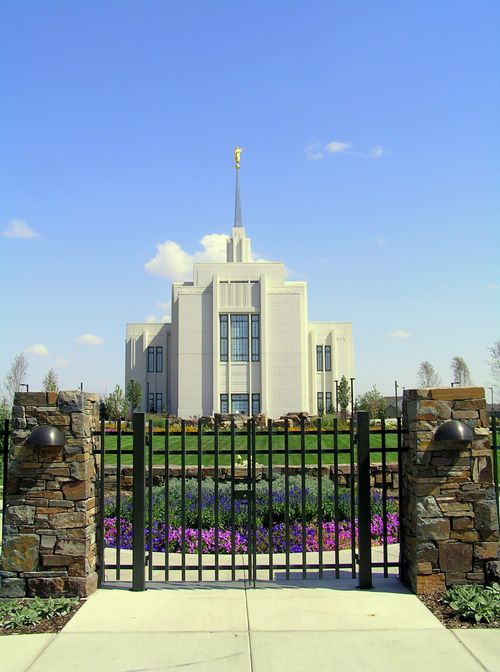 The Twin Falls Idaho Temple during daytime, from the back, with the gate entrance to the grounds.
