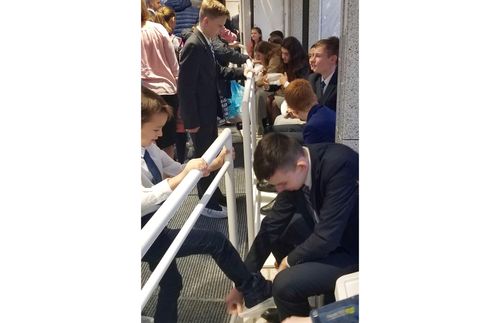 young man helping put shoe covers on