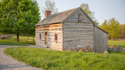 Joseph Smith, Sr. and Lucy built a log house in the woods south of the village of Palmyra, New York. Around 1818, they moved their family, including 8 children into the house on the property of 100 acres. Joseph Smith lived in the home in 1820 at the time of his first vision and later with the visitations of the angel Moroni. This replica was built in 1998. Photo taken May 2022.