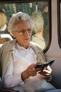 A Brazilian woman reading the scriptures.  She is sitting on a bus.