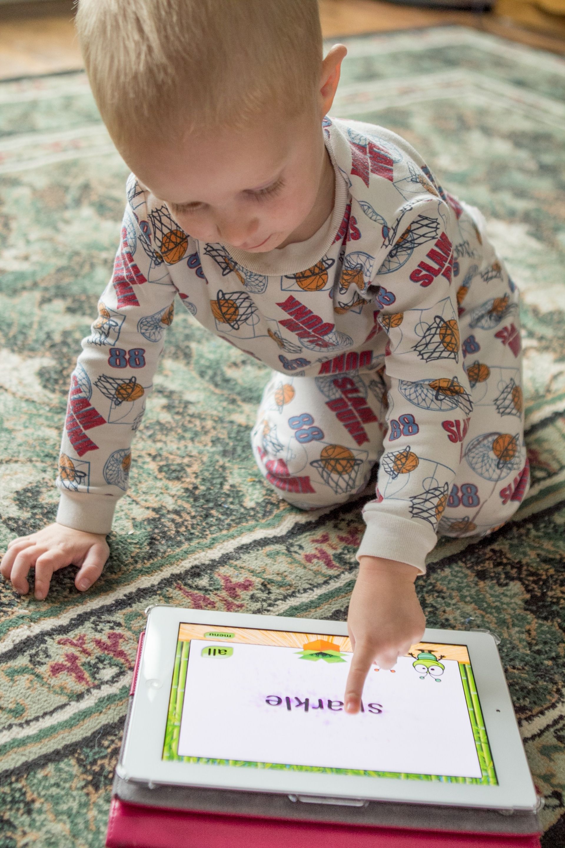 A baby plays a game on a tablet.