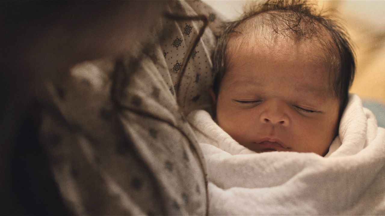 Two parents hold their newborn