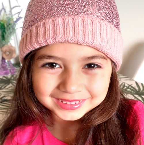 A photo Camila Castrillon. She is smiling wearing a pink hat and shirt.