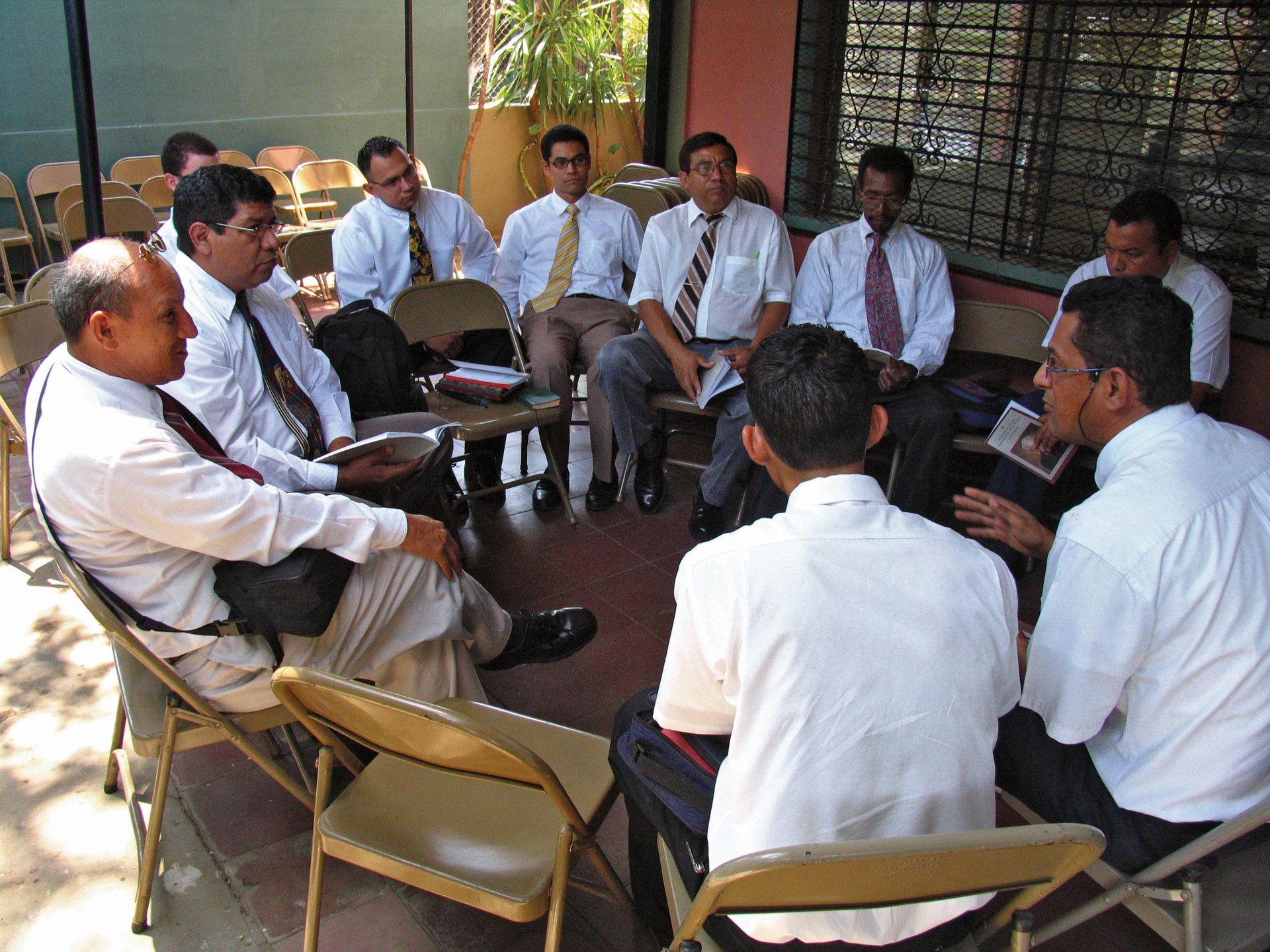 Members of an elders quorum sit in a circle to discuss teachings of the prophets.