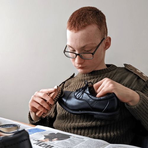 young man polishing shoe