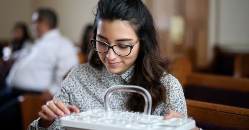 Une jeune fille prenant l’eau de la Sainte-Cène.