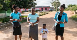 šťastné misionářky se ženou a dítětem, které učí