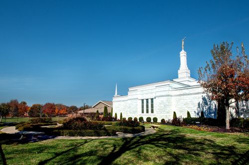 The Nashville Tennessee Temple and grounds in the fall, with fall leaves on the trees and a clear blue sky overhead.