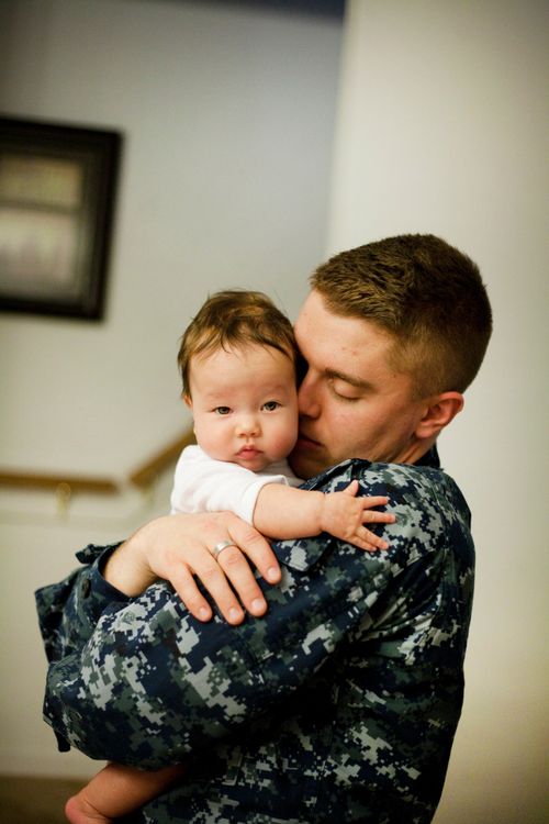 Male soldier holding a baby