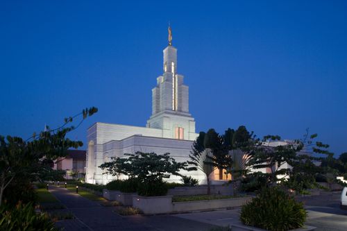 A wide-angle shot of the Accra Ghana Temple and all of its grounds lit up at night.