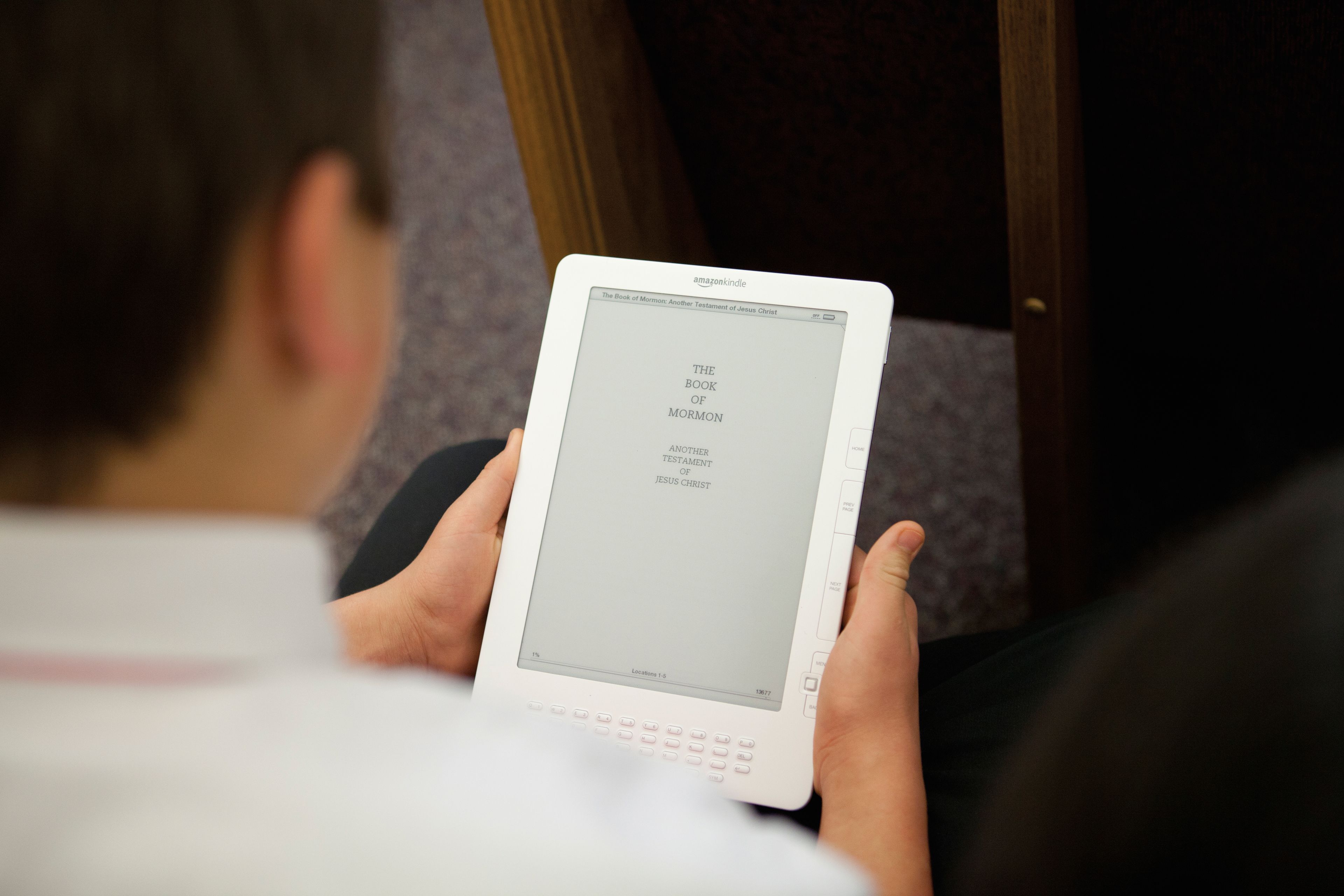 A young boy holds a tablet in his hands and starts reading the Book of Mormon.
