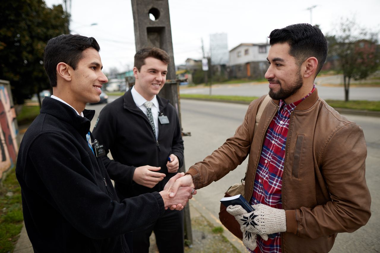 Missionários conversando com um homem na rua