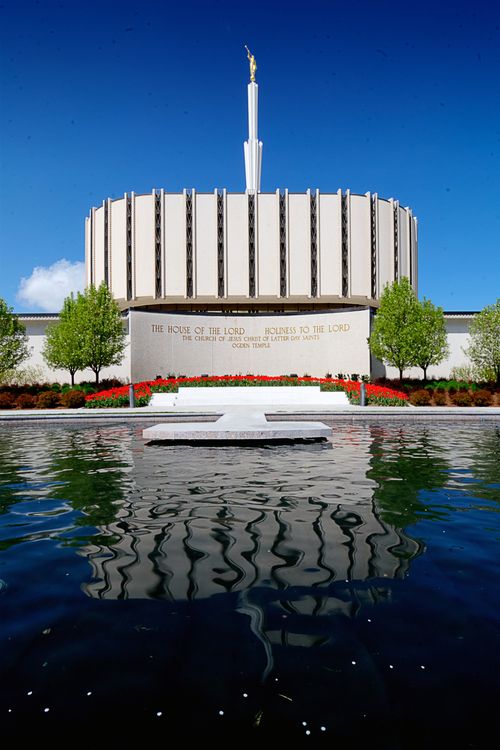 A pool of water on the grounds of the old Ogden Utah Temple, with the temple’s sign in front of the temple, which is seen in the background.