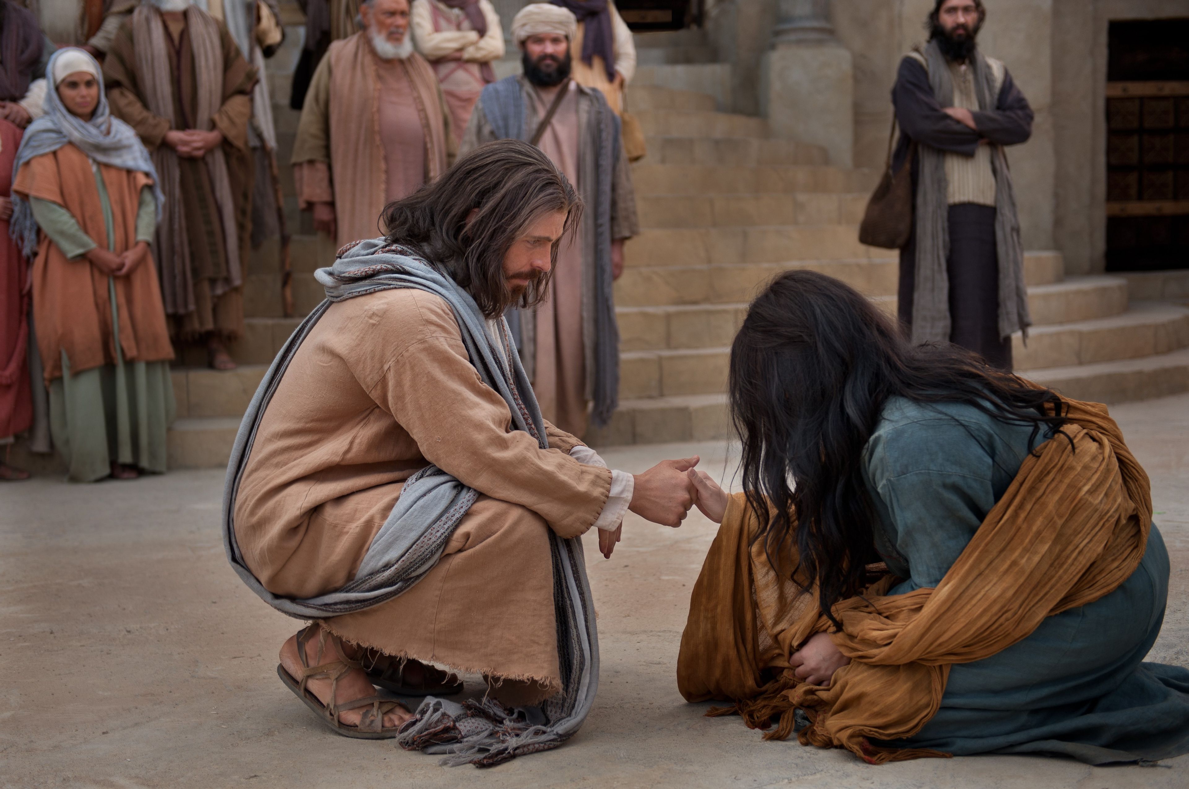 Jesús tiende Su mano para ayudar a la mujer sorprendida en adulterio.