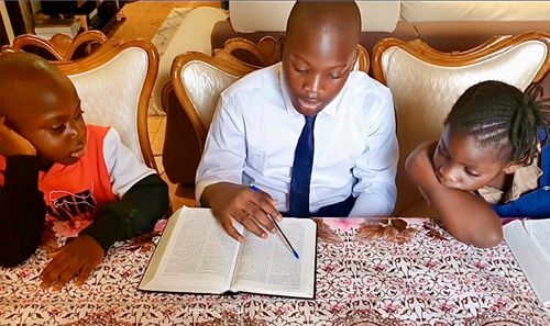 Nathan reading with his younger siblings