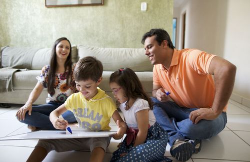 Young family in Brazil read together, parents teach children with drawings, they sing together, mother reading, father holding up chart etc.