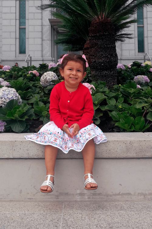 A young girl named Shirley sits outside the Tegucigalpa Honduras Temple.