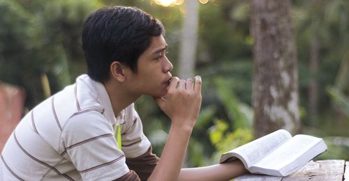 young man contemplating scriptures