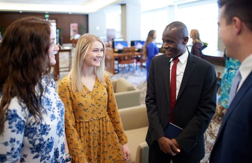 a group of young adults talking and laughing together