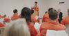 Various men in a correctional facility attend a church meeting. 