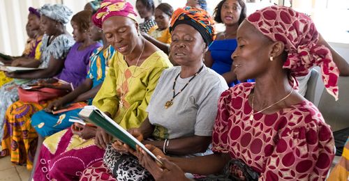 women singing from a hymnbook