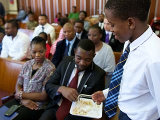 priest passing the sacrament to congregation