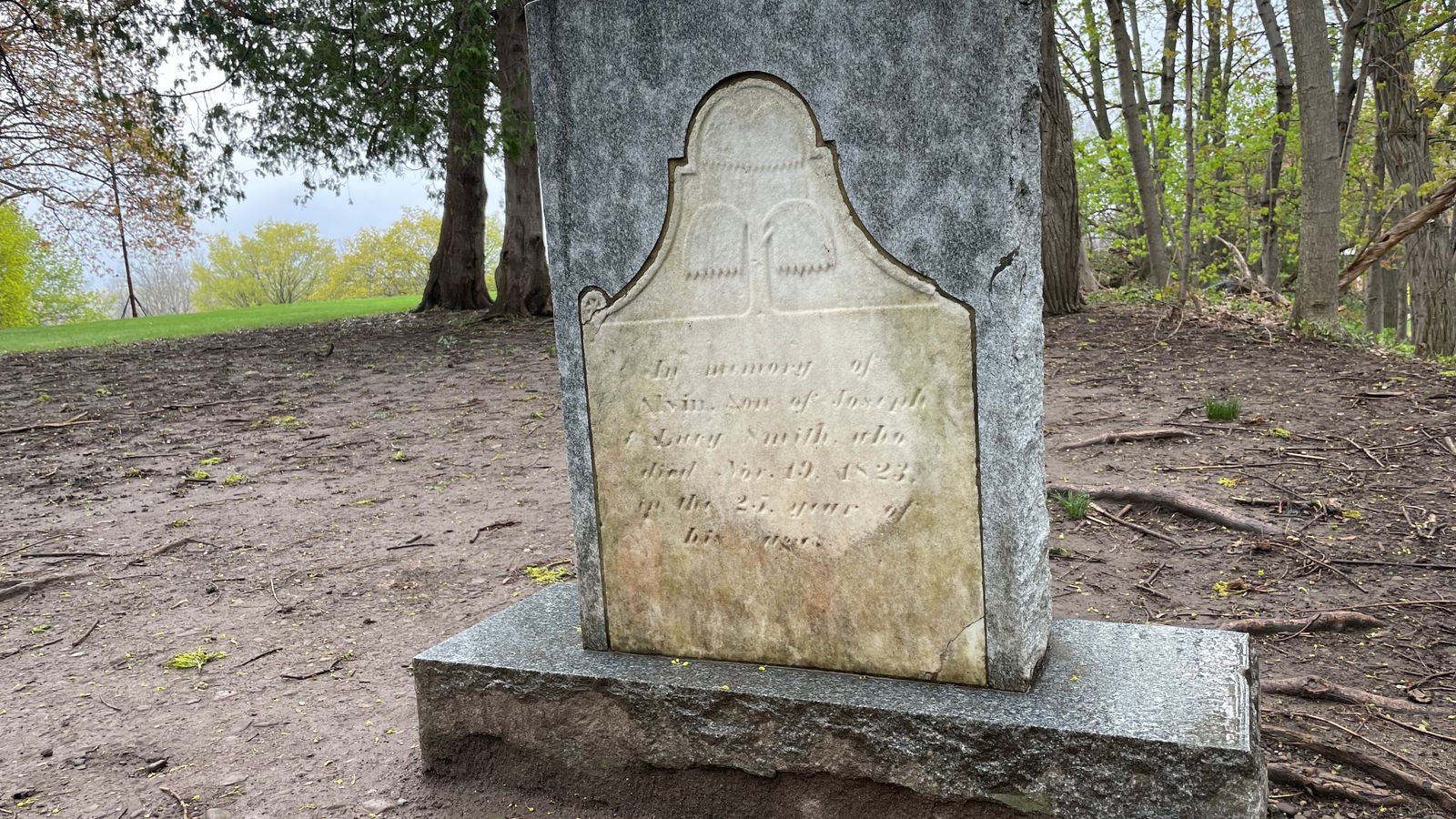 An old headstone encased in new granite. The engraving reads ‘In Memory of Alvin, Son of Joseph and Lucy Smith, who died Nov. 19, 1823, in the 25th year of his life.’ 