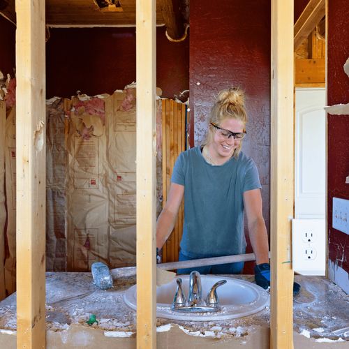 young woman with a sledgehammer at a construction site