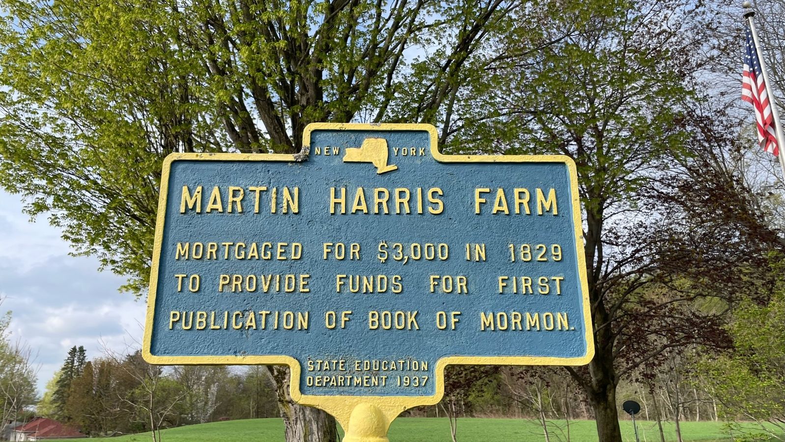 A metal sign that says the Martin Harris Farm. 