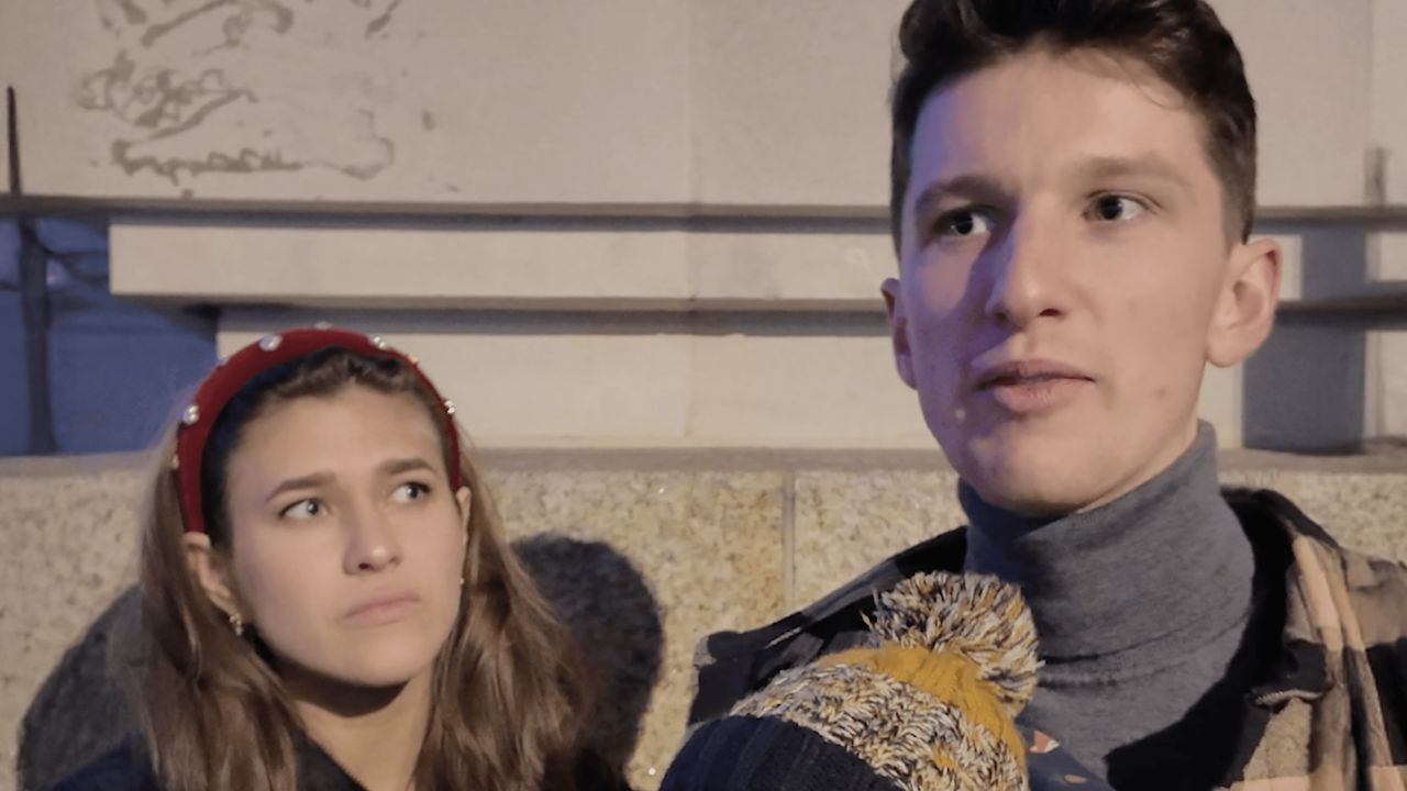 Um jovem casal conversa em uma entrevista na rua