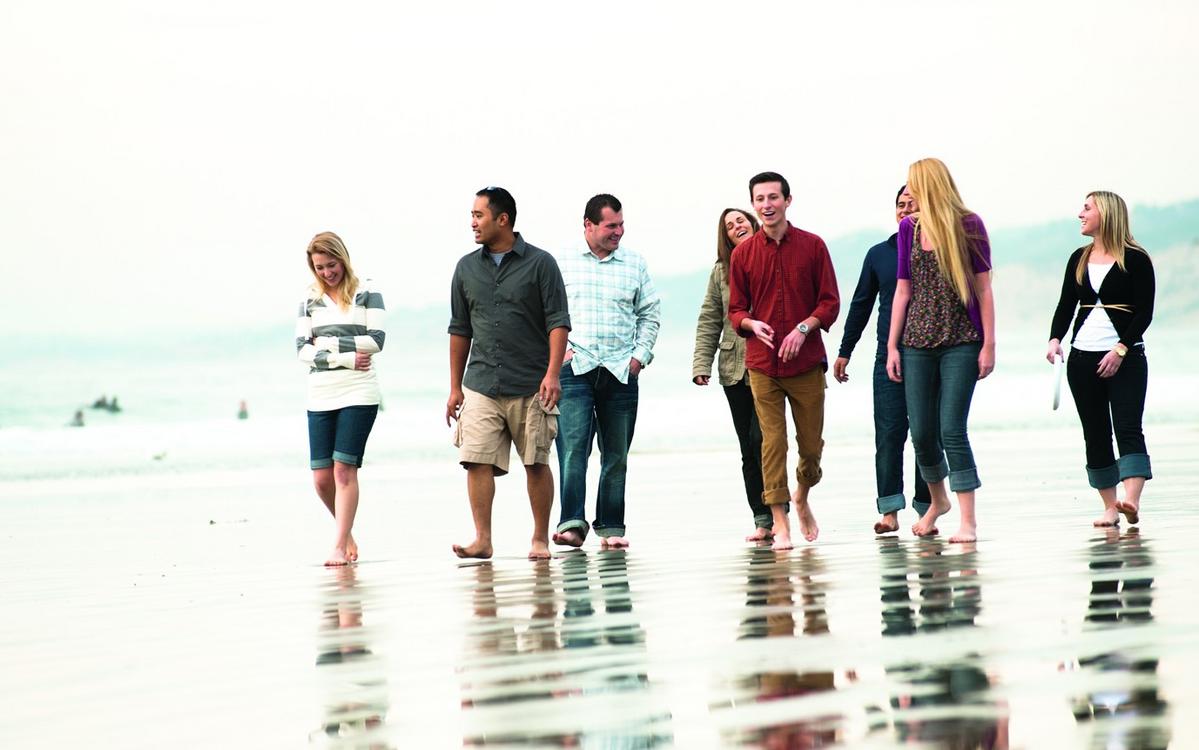 Young single adults walking on the beach.